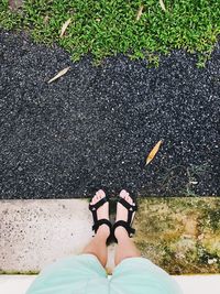 Low section of woman standing on footpath