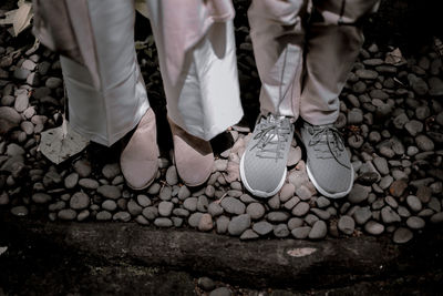 Low section of people standing on pebbles