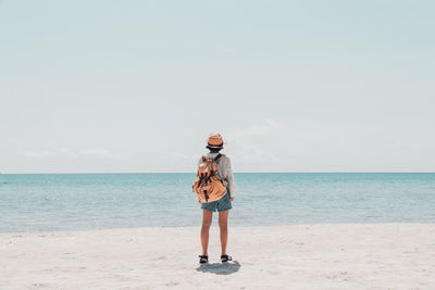 Full length of man standing at beach against sky
