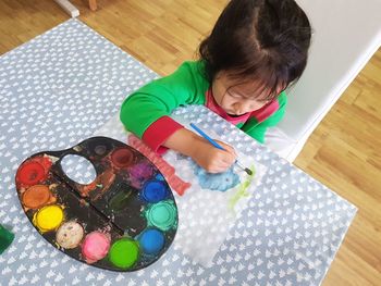 High angle view of girl painting on table