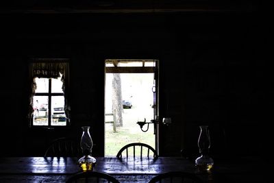 Glass of bottles on table in window