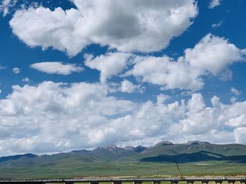 Scenic view of field and mountains against sky