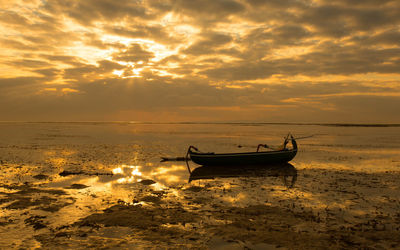 Boats in sea at sunset