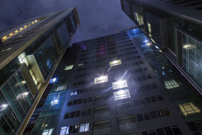 Low angle view of illuminated buildings in city at night