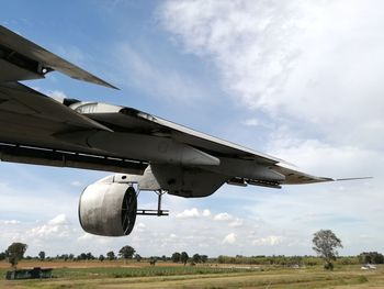 Airplane flying over land against sky