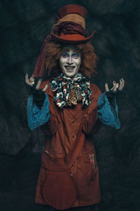 Portrait of man wearing costume against black background