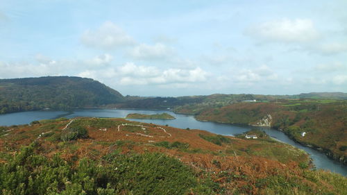 Scenic view of river and mountains against sky