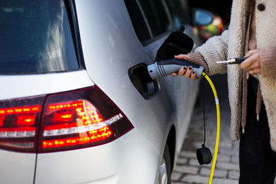 Woman charging electric car