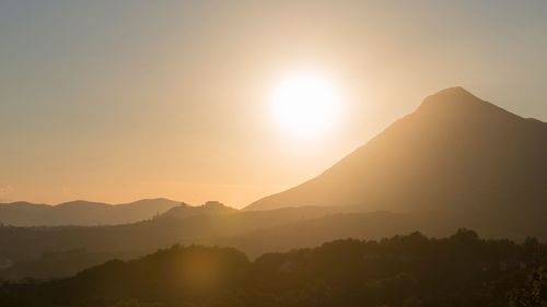 Scenic view of silhouette mountains against clear sky during sunset