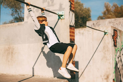 Full length of boy with umbrella on sunny day