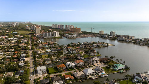 High angle view of townscape by sea against sky