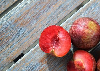 Close up view on red plums at wooden surface