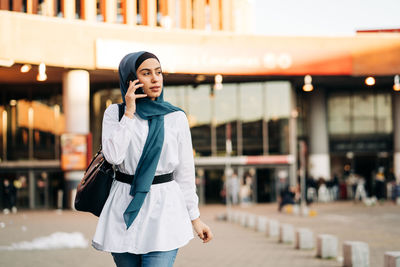 Young woman using phone while standing outdoors