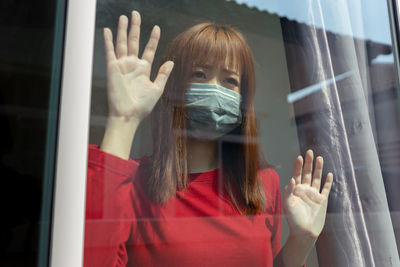 Portrait of woman seen through glass window