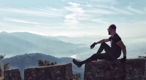 Man standing on mountain against sky