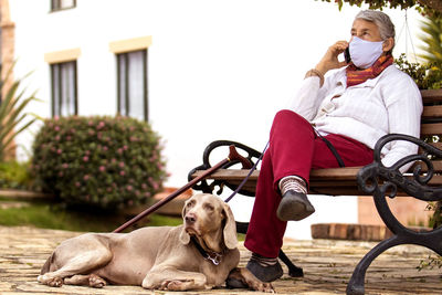 Man with dog sitting on street against white background