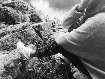 Low section of person holding rock in river