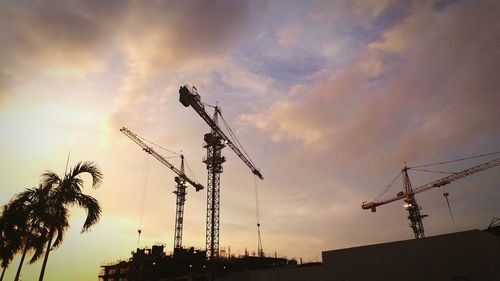 Low angle view of silhouette building against cloudy sky