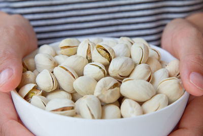 Close-up of hand holding eggs in bowl