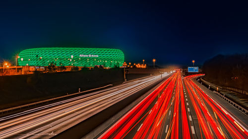 Light trails on road against sky at night
