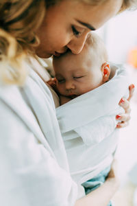 Mother carrying newborn son at home