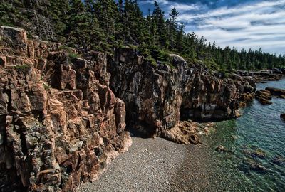 Panoramic view of rock formation amidst trees against sky