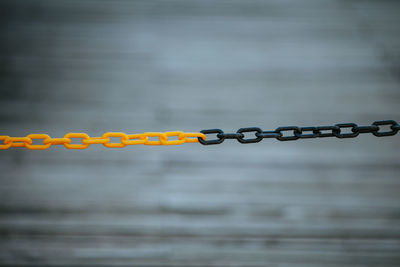 Close-up of chain against grey wall