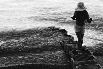 High angle view of woman walking on rocks at beach