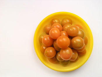High angle view of fruits in bowl over white background