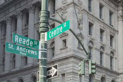 Low angle view of road sign against building in city