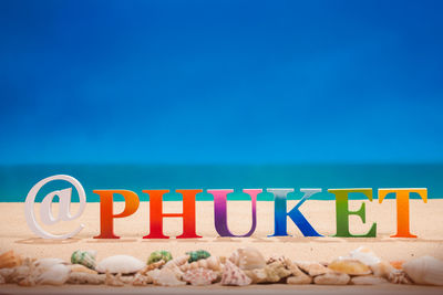 Information sign on beach against blue sky