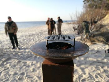 People at beach against clear sky