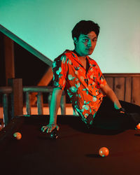 Young man playing with ball on table