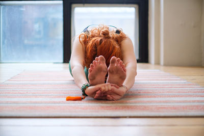 Rear view of woman sitting on floor