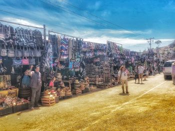 People at street market in city against sky