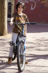 Portrait of boy on bicycle during sunny day