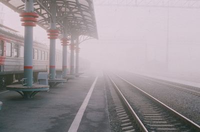 Railroad tracks in foggy weather against sky