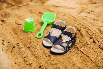 High angle view of toys and sandals on sand