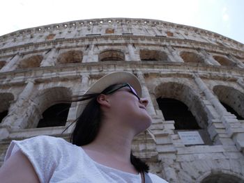 Low angle portrait of woman with historic building