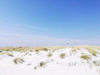 Scenic view of snow covered land against blue sky