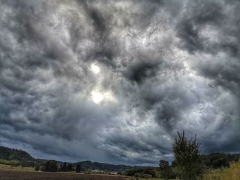Scenic view of storm clouds over plants