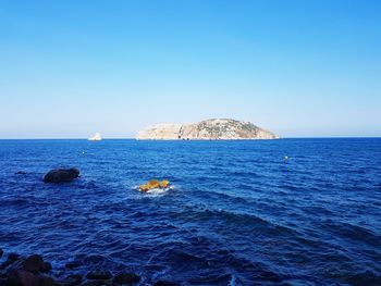 Scenic view of sea against clear blue sky