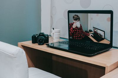 Midsection of man using mobile phone while sitting on table