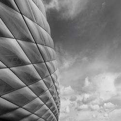 Low angle view of modern building against cloudy sky