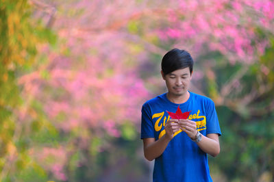 Full length of boy holding purple flower