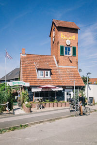 Street by buildings in town against blue sky