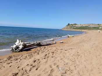 Scenic view of beach against clear blue sky