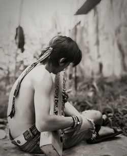 Side view of young woman sitting outdoors