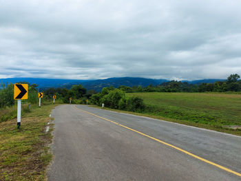 Road amidst field against sky