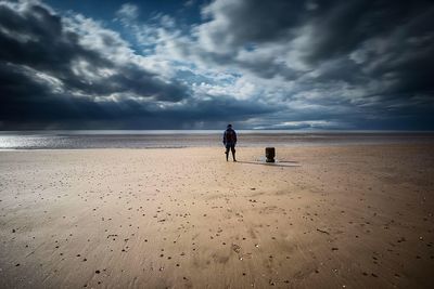 Scenic view of beach against cloudy sky
